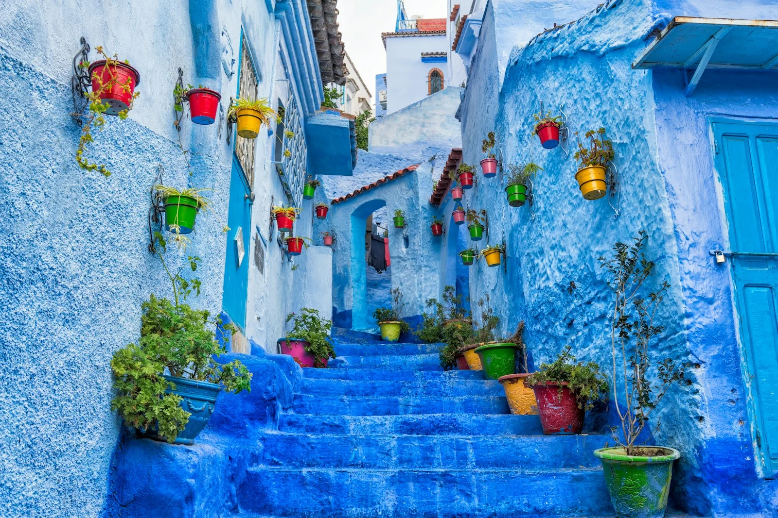 Morocco's Labyrinthine Village - a narrow street with blue steps and potted plants
