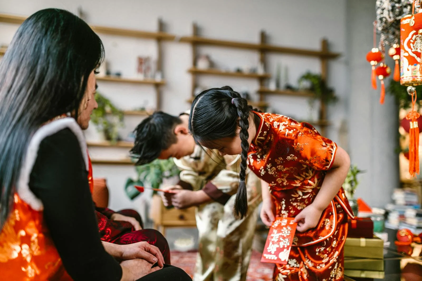 7 Unique Cultures in the World in January: Discover Them Now! A family gathering for Chinese New Year, exchanging red envelopes and wearing traditional attire indoors.
